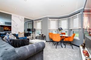 a living room with a couch and chairs and a table at The Apartment in Paisley
