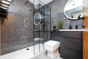 a bathroom with a shower and a toilet and a sink at The Apartment in Paisley