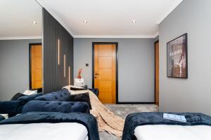 a room with four blue couches in front of a door at The Apartment in Paisley