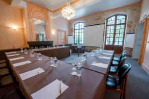 Sérignac-sur-GaronneにあるLogis Hotel Le Prince Noirの大きな会議室(長いテーブルと椅子付)