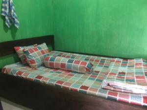 a bed with two pillows on top of it at Mudung Keramat Homestay in Sapit