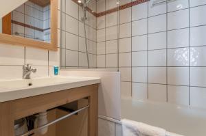 a bathroom with a sink and a bath tub at Residence Les Chalets des Arolles - maeva Home in Mâcot La Plagne