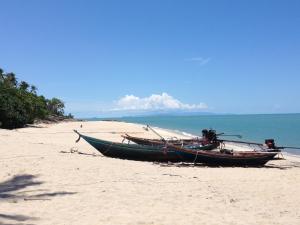 two boats sitting on the sand on a beach at Thai Life Guesthouse - SHA EXTRA PLUS in Khao Lak