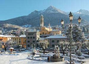 a town in the snow with a mountain in the background at Euro Hotel in Edolo