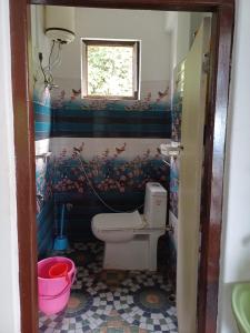 een kleine badkamer met een toilet en een raam bij Jun Homestay in Kalimpong