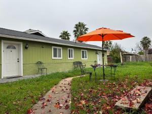 a house with a table and an umbrella in the yard at Cozy suite B in Sacramento