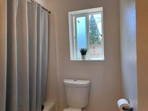 a bathroom with a toilet and a window at Cozy suite B in Sacramento