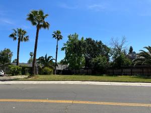 an empty street with palm trees and a house at Cozy suite B in Sacramento