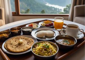 einen Tisch mit einem Tablett mit Essen auf dem Tisch in der Unterkunft Kanara Hotel in Bhīm Tāl