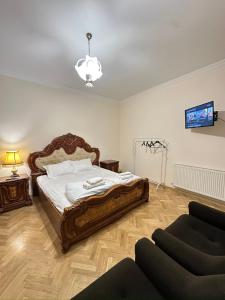 a bedroom with a large bed and a couch at Davit's Apartments 21 in Tbilisi City