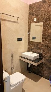 een badkamer met een wit toilet en een wastafel bij Hotel Simran Desert View Haveli in Pushkar