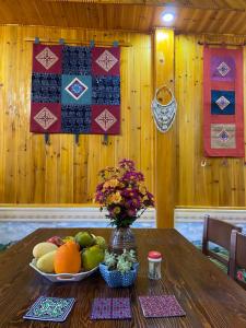 un tavolo con un cesto di frutta e un vaso di fiori di Sen Sapa Retreat & Tours a Sa Pa