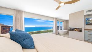 a bedroom with a large bed and a large window at 'Ocean Pearl' by HolidayCo in Hardys Bay