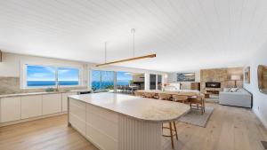 a kitchen and living room with a table and chairs at 'Ocean Pearl' by HolidayCo in Hardys Bay