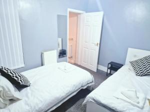 zwei Betten in einem Zimmer mit blauen Wänden in der Unterkunft Stylish Modern Home comfy setting by Everton Park in Liverpool