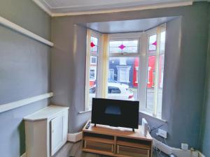 ein Wohnzimmer mit Fernseher und Fenster in der Unterkunft Stylish Modern Home comfy setting by Everton Park in Liverpool + 15 Fotos