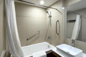 a bathroom with a tub and a sink and a shower at Rothman Hotel in Manila +6 photos