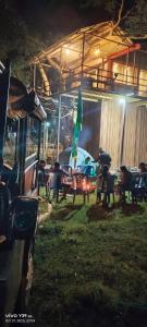 eine Gruppe von Tischen und Stühlen in einem Garten in der Nacht in der Unterkunft Wild Ni8 Club 