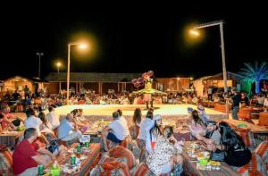 斋沙默尔Desert Villa Resort & Camp Jaisalmer的一群坐在聚会桌旁的人