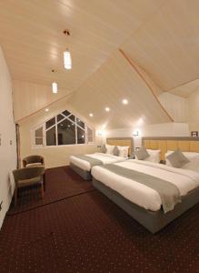 a bedroom with two beds and a chair at Venture Vista Gulmarg in Jāmb