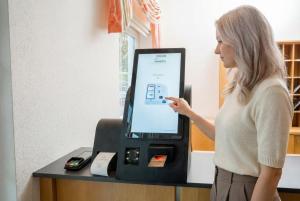 a woman is standing next to a cash register at Hotel Nummerhof in Erding