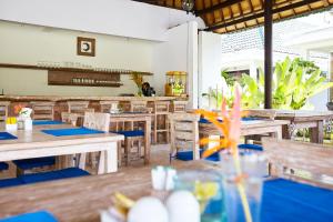an empty restaurant with wooden tables and chairs at M-Apartment in Badung