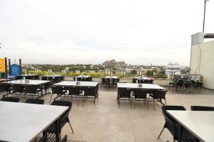 a patio with tables and chairs on a roof at Hotel Rock Fort View in Tiruchirappalli