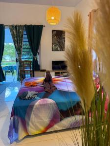 a woman sitting on a bed in a room at Vaihi's Garden climatisé, vue sur mer - Huahine in HUH