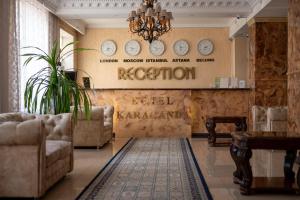 a waiting room with clocks on the wall and chairs at Гостиница Караганда in Karagandy