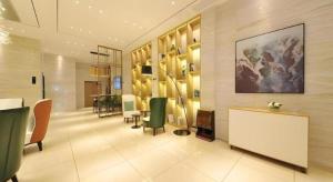 a lobby with chairs and a table in a building at City Comfort Inn Chengdu Wenjiang University Town Fengxi River Metro Station in Chengdu