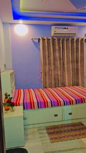 um quarto com uma cama com um cobertor arco-íris listrado em Bloosoms Nest em Jāmb