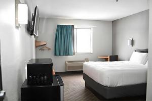 een hotelkamer met een bed en een laptop op een tafel bij Rodeway Inn Hibbing in Hibbing