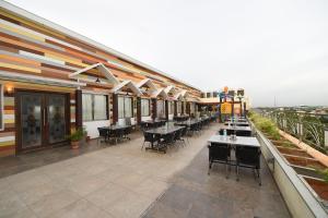a restaurant with tables and chairs on a patio at Hotel Rock Fort View in Tiruchirappalli