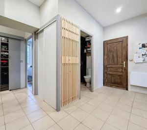 a bathroom with a toilet and a wooden door at Appartement 3 Pièces, Neuvecelle in Neuvecelle