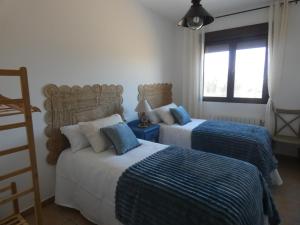 una camera con due letti con lenzuola blu e bianche di El Refugio de Hugo a Benablón