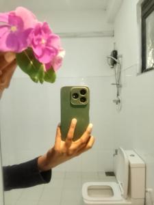 iemand die een foto maakt van een badkamer met een bloem bij Goyambokka Beach front pool resort in Tangalle