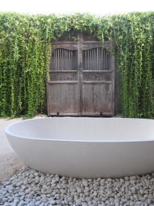 a white bath tub sitting on a pile of rocks at Villa Samudera in Nusa Lembongan +70 photos