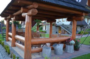 um gazebo de madeira com uma mesa e cadeiras em Jedla Miejsce Gościnne em Bukowina Tatrzańska