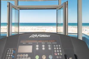 a gym with a view of the beach at Strand-Hotel Hübner in Warnemünde