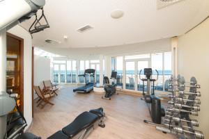 a gym with treadmills and exercise equipment in a building at Strand-Hotel Hübner in Warnemünde