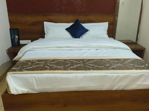 een slaapkamer met een groot bed met een blauw kussen bij Hotel Rudra Varanasi in Varanasi