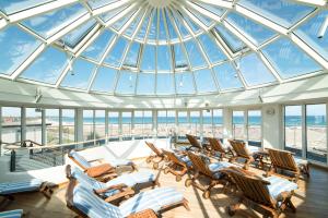 a room with chairs and a glass domed ceiling at Strand-Hotel Hübner in Warnemünde