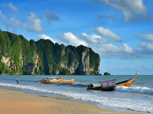 three boats sitting on the shore of a beach at Krabi Grand Place Hotel in Ban Khlong Chi Lat