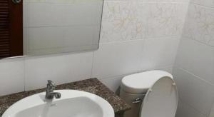 een badkamer met een wastafel, een toilet en een spiegel bij Palm Hill Resort in Khanom +39 foto's
