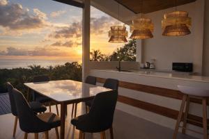 - une cuisine avec une table et des chaises et une vue sur l'océan dans l'établissement NAHA Villa Sea View Koh Phangan, à Baan Tai