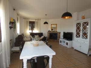 un soggiorno con un tavolo e una tv di El Refugio de Hugo a Benablón