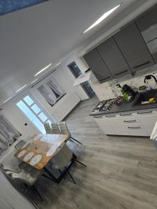 una cucina con mobili bianchi e un tavolo di legno di Casa Valy a Buşag