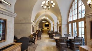 a dining room with tables and chairs and a chandelier at Shamas Hotel in Midyat