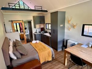 a bedroom with a bed and a table and a kitchen at Spasie 30 Harties in Hartbeespoort