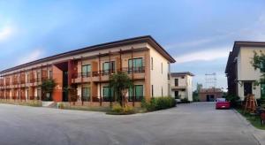 a building with a car parked in a parking lot at Villa Thiwa Hotel in Ban Na Po Tai